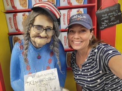 pic of woman standing next to sculpture of older woman