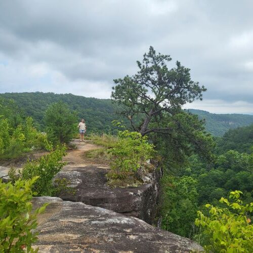 pic of woman standing on rock outcrop